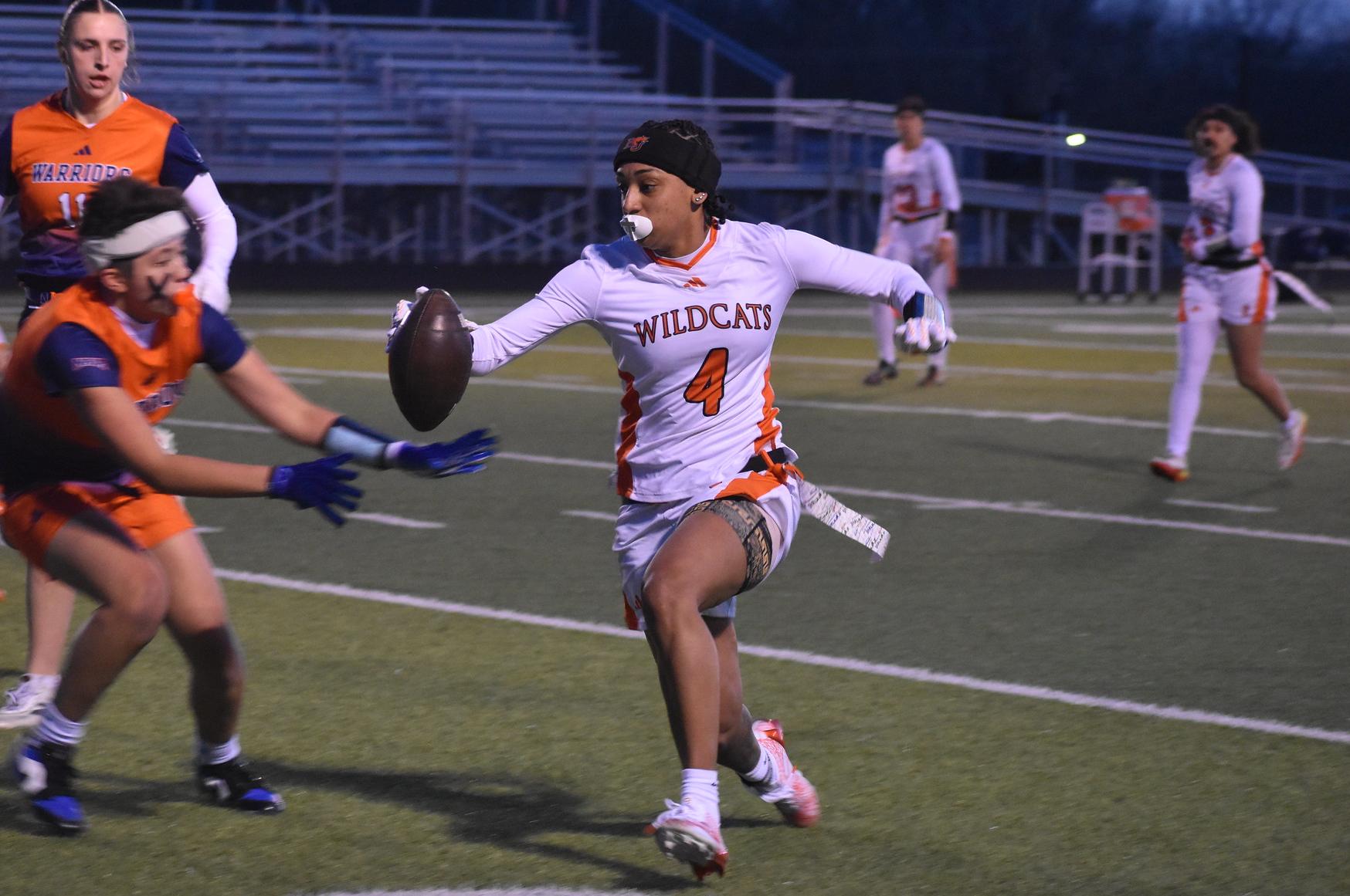 Baker women's flag football player Kaley Phillips running the ball at home against Midland